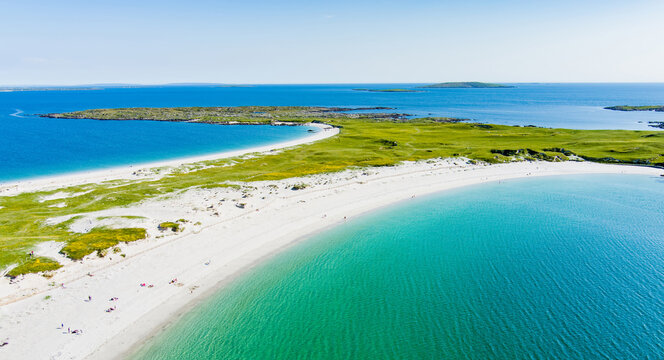 Aerial view of Dogs Bay and Gurteen Bay near Roundstone, Connemara, County Galway, Ireland. Scenic twin beaches with white sand and contrasting turquoise and blue Atlantic water.