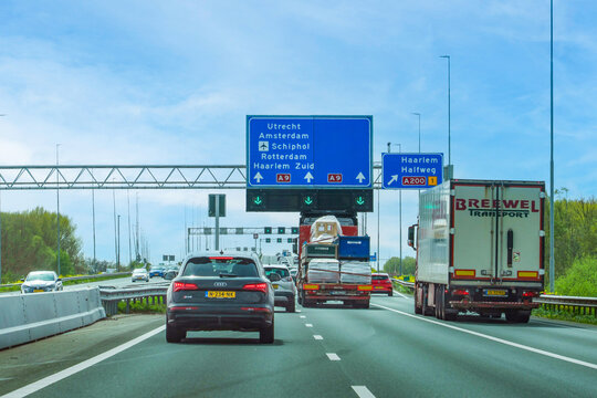 Netherlands - April 17, 2026: Heavy traffic on the A9 motorway with blue overhead directional signs for Utrecht, Amsterdam, Schiphol Airport, Rotterdam, Haarlem, and Halfweg.