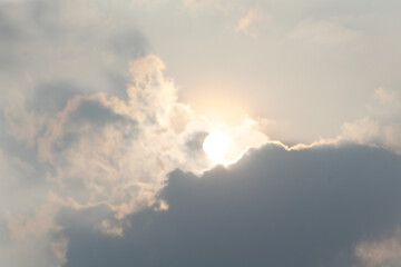 Obraz premium Bright Sun Peeking Through Dark Dramatic Clouds in a Scenic Sky