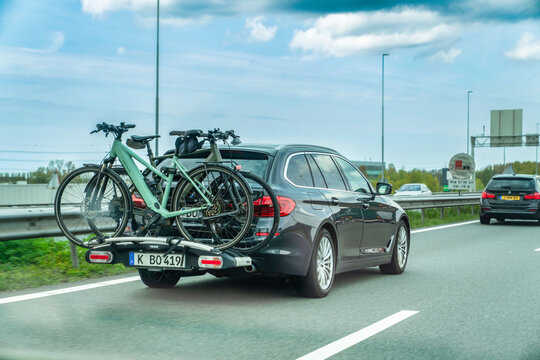 Netherlands - April 17, 2026: A dark station wagon carrying electric bicycles on a rear-mounted rack drives along a Dutch highway during daytime, illustrating active lifestyle and sustainable travel.