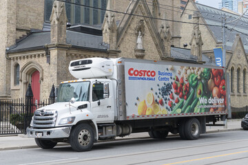 Fototapeta premium Costco Business Centre refrigerated delivery truck stopped outside the east facade of St Michael's Cathedral Basilica (Church St side), Toronto