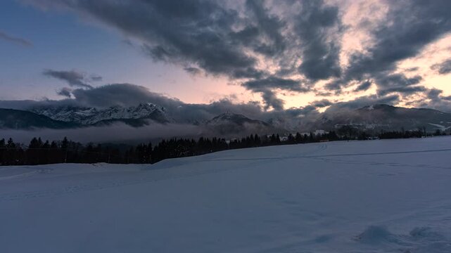 rapido e breve video timelapse che mostra un ambiente naturale di montagna innevato, in Italia, in inverno, al tramonto, con cielo nuvoloso