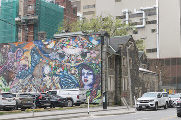 Fototapeta premium mural on the exterior of 53 Shuter St (once Metropolitan United Church Parsonage) with St Michael's hospital complex behind, Toronto