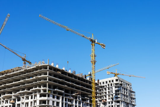 Midrise construction site with tower cranes, sustainable urban development progress