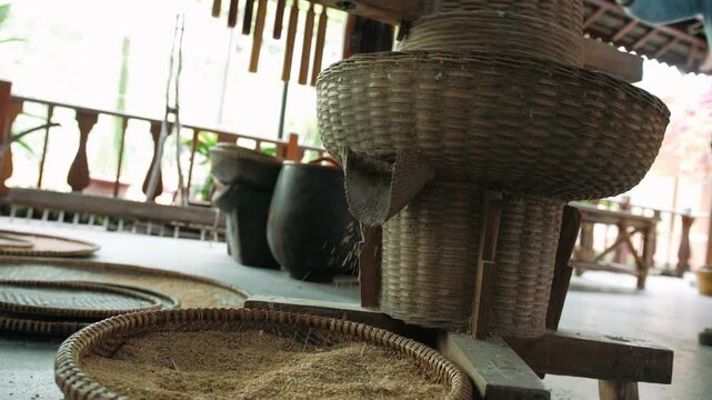 Traditional vietnam rice mill separating grain from husk using a manual bamboo threshing machine for processing