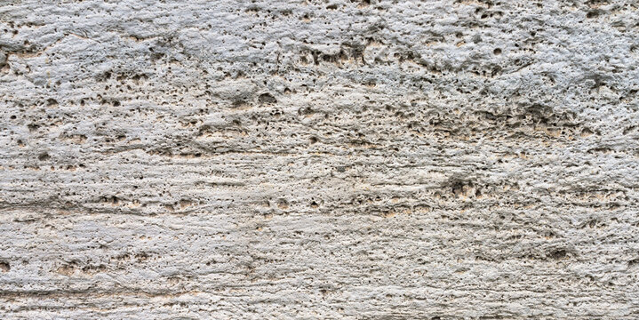 Texture of natural travertine or limestone tufa with a porous structure. Lightweight, structured natural finishing stone. Limestone background