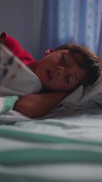 Young boy sleeping peacefully in bed at home resting after day concept of comfort security and healthy childhood routine