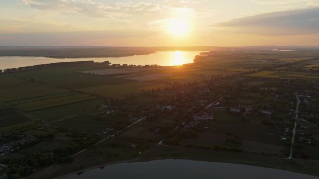 Breathtaking aerial sunset over the Costesti-Stinca reservoir in Moldova. Drone view of the golden sun reflecting on the water at the Romanian border near the village of Duruitoarea Noua.