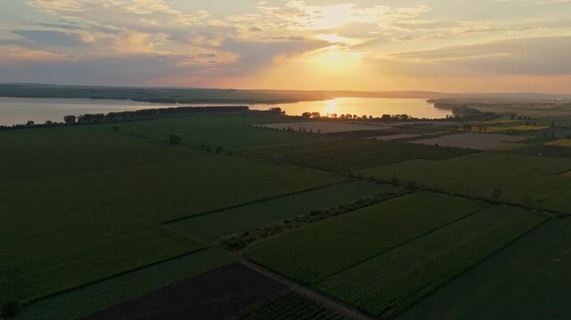 Scenic aerial sunset over the Costesti-Stinca reservoir in Duruitoarea Noua, Moldova. Panoramic view of the water border between Moldova and Romania with golden sun reflecting on the surface.