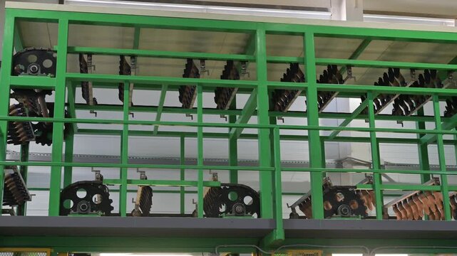 Automated factory conveyor with glove molds used in latex glove manufacturing process, showing industrial equipment for protective medical and safety gloves.