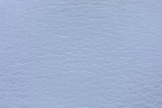 vista macro di una superficie coperta di neve fresca e omogenea e dalle tonalit&agrave; di azzurro chiaro