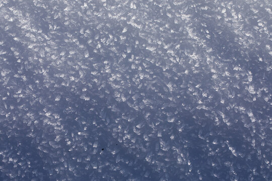 superficie coperta da bellissimi cristalli di neve ghiacciata dalle tonalit&agrave; di azzurro, foto con vista macro