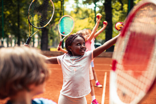 Children practicing tennis drills on outdoor clay court