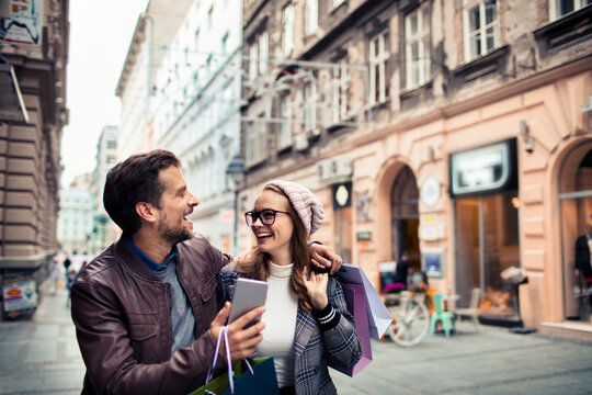 Young couple shopping and laughing on historic european city street