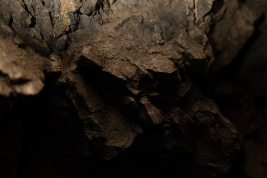 dettagli di una parete rocciosa interna ad una cavit&agrave; naturale nella penombra