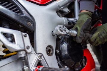 Fototapeta premium An outdoor scene depicts technician meticulously extracting bolt from engine cover with sharp focus