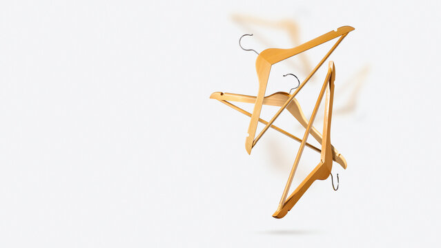 Floating, levitation beige wooden hangers fly on light gray background. Creative concept fashion sale, seasonal discounts, retail marketing campaign and clothing store advertising. Copy space. Banner