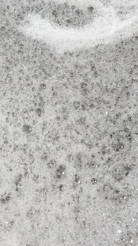 Thick soap suds shimmy and gyrate in kitchen sink