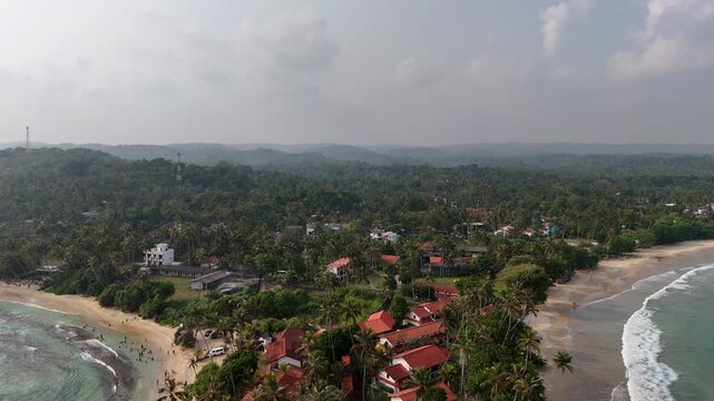 Aerial View Above Dickwella Bay Tropical Coastline Sri Lanka
Aerial drone footage above Dickwella Bay resort coastline and turquoise ocean Sri Lanka May 2026.
