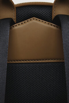 A close-up of a fashion bag against a white background. The texture of the leather and fabric