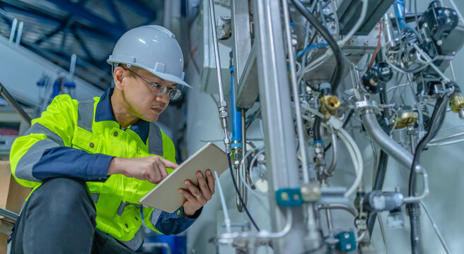Asian electric engineer holding clipboard for checking and monitoring the electrical system in the control room,Technician thailand people working