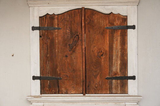 Rustic Weathered Wooden Shutters with Black Hardware on Neutral Wall Exterior Architectural Detail for Home Security and Privacy