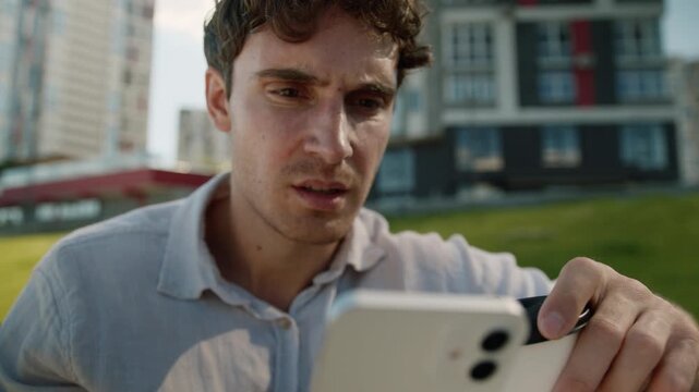 Serious Caucasian business man looking in mobile phone drinking coffee feeling confusion businessman male guy employer user look in smartphone reading bad news worried anxiety reaction shock in city