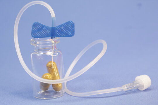 Capsulas dentro de frasco de vidrio con un fondo azul.