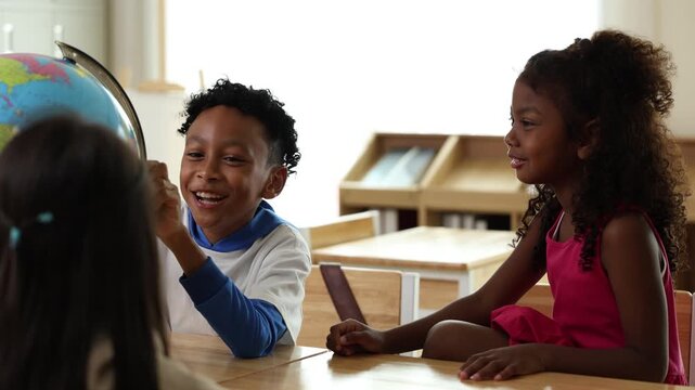 Three children gathered around a globe, with one boy pointing at it and a girl watching attentively in a classroom setting.