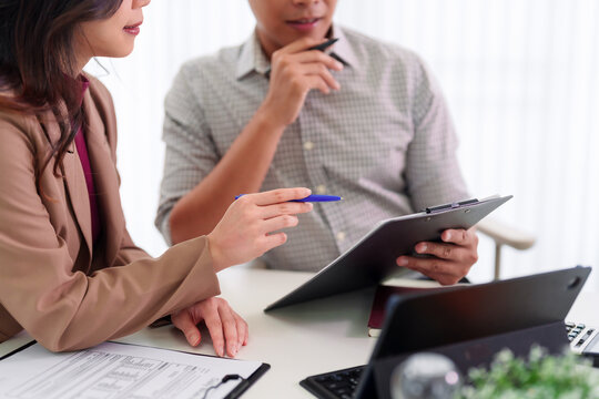 Asian business team meeting office discussion corporate planning strategy documents professional colleagues collaboration workplace finance report review
