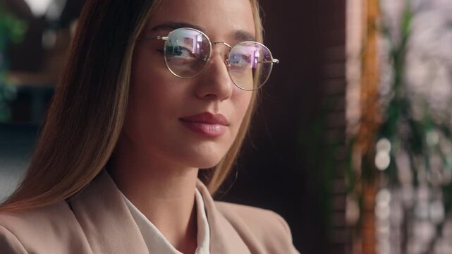 Caucasian business woman putting on glasses smiling looking at camera toothy smile girl female businesswoman put on eyeglasses joyful positive employer specialist indoors in office eyesight health