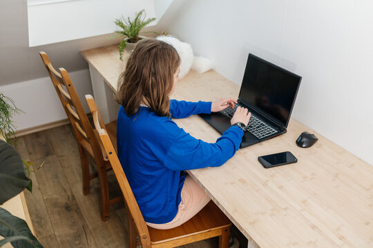 Young girl learning from home using laptop
