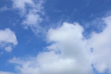Obraz premium Bright blue sky with fluffy white clouds and scattered
