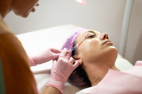 Woman receiving facial filler injection for anti-aging beauty treatment