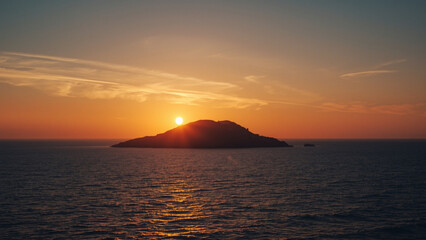 Fototapeta premium Golden Sunset Behind Island Over Calm Ocean