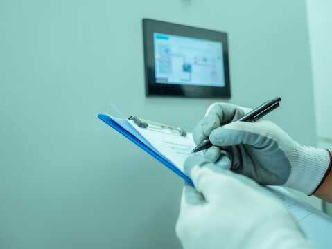 Close up hand engineer checklist continuous emission monitoring system in control electric power at factory. Technician analysis management air pollution reduction system industrial. Environment work