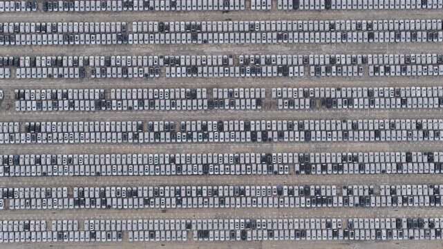 Top down view of thousands of new cars in orderly rows at automobile export yard