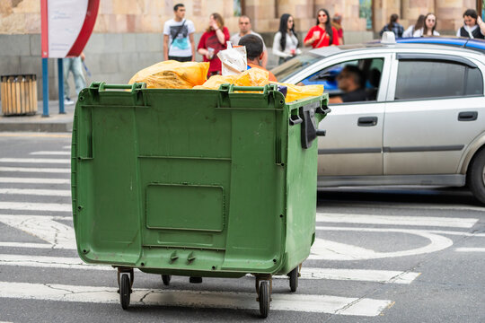 Street trash bin placed in urban environment for public waste collection, sanitation infrastructure, cleanliness maintenance, and everyday city hygiene concept.
