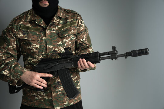 Masked armed individual in urban environment, security incident scenario, law enforcement focus, public safety concern, and high-alert situation concept.