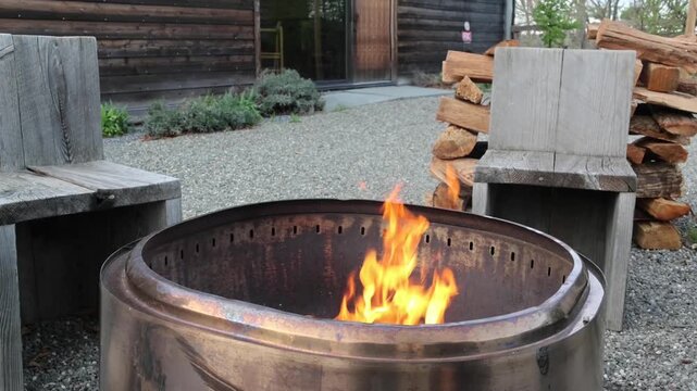 fire pit burning with red orange yellow flames outside barn rustic restaurant upstate new york hudson valleyround circle burn logs at sunset in catskills mountains catskill wood wooden log warmth cozy