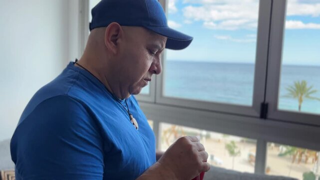 Hombre pensativo mirando por la ventana mientras toma t&eacute;