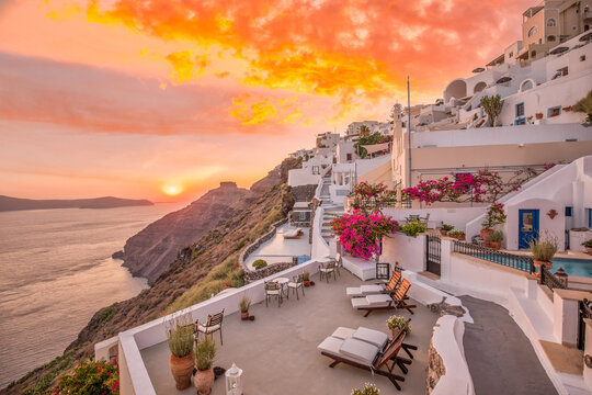 Santorini sunset terrace pink dramatic sky white architecture Oia Greece breathtaking Mediterranean luxury resort travel destination romantic Cyclades caldera view iconic coastal cliffside background