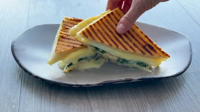 Eating an Egg White and Spinach Breakfast Sandwich Panini