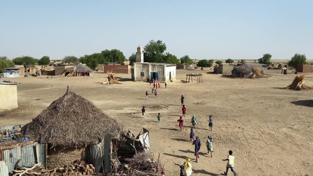 Drone view of African children running toward village mosque, April 25, 2026, Chad, N Djamena