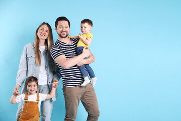 Fototapeta premium Portrait of happy family on light blue background, space for text