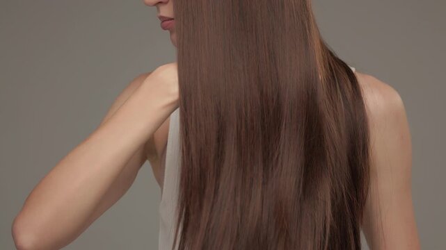 Woman Creating Hair Wave with Long Brown Hair Close Up