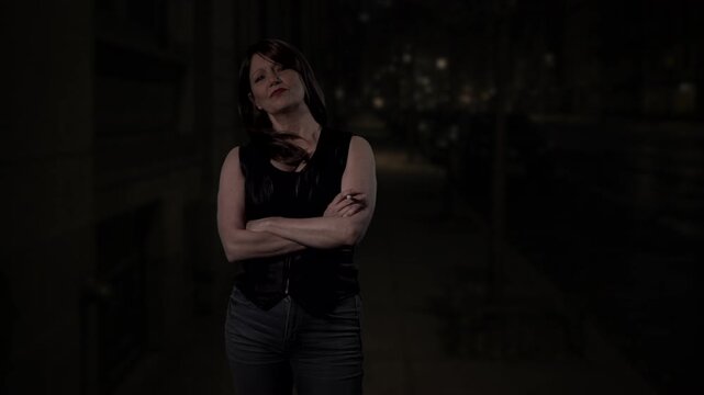 Woman standing on a dark street