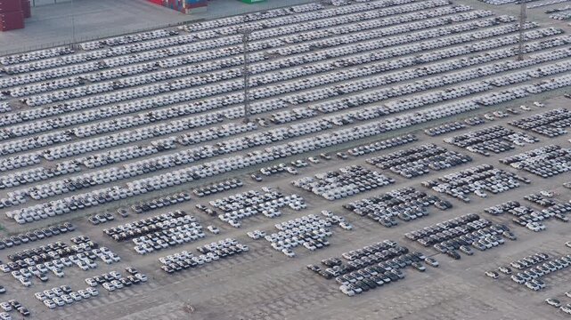 Top down aerial view of illuminated automobile storage yard at night