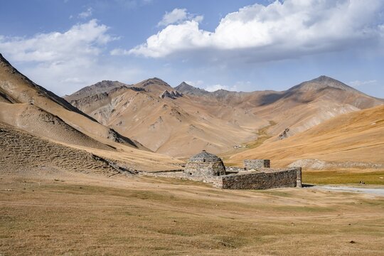 Historic caravanserai Tash Rabat from the 15th century, with yellow hills, Atbashy district in the Naryn region, Kyrgyzstan