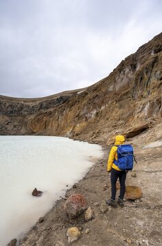 Hiker at the crater lake V&iacute;ti in the crater of the volcano Askja, mountain massif Dyngjufj&ouml;ll, Iceland